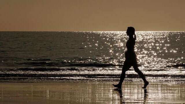 Una mujer camina por la orilla de la playa de Maspalomas, en el sur de Gran Canaria.