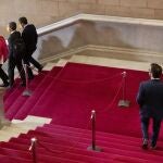 El candidato de ERC a la presidencia de la Generalitat, Pere Aragonès, baja las escaleras del Parlament detrás de los diputados de JxCat, Gemma Geis, Joan Canadell, y Josep Rius, durante un receso de la segunda sesión del debate de su investidura