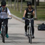 Dos mujeres circulan en bicicleta, en el Parque del Manzanares