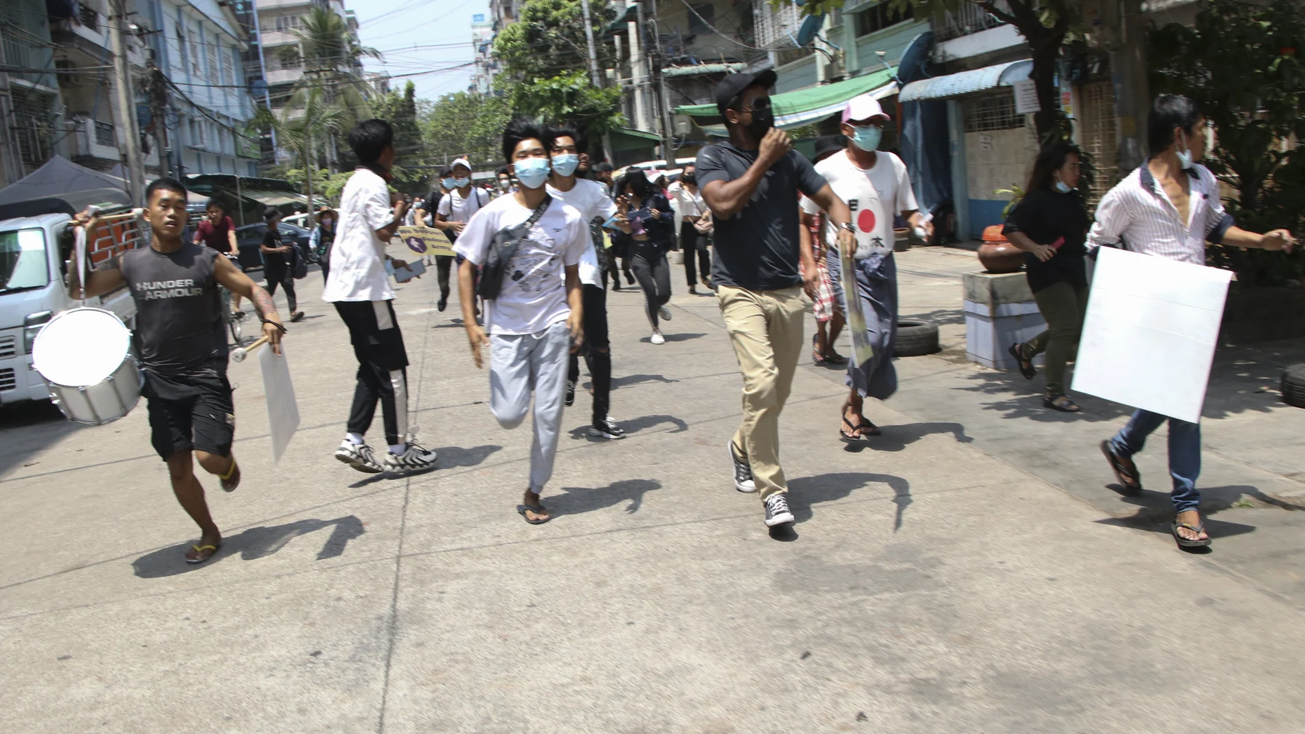 Manifestantes antigolpistas corren para evitar las fuerzas militares durante una manifestación en Yangon