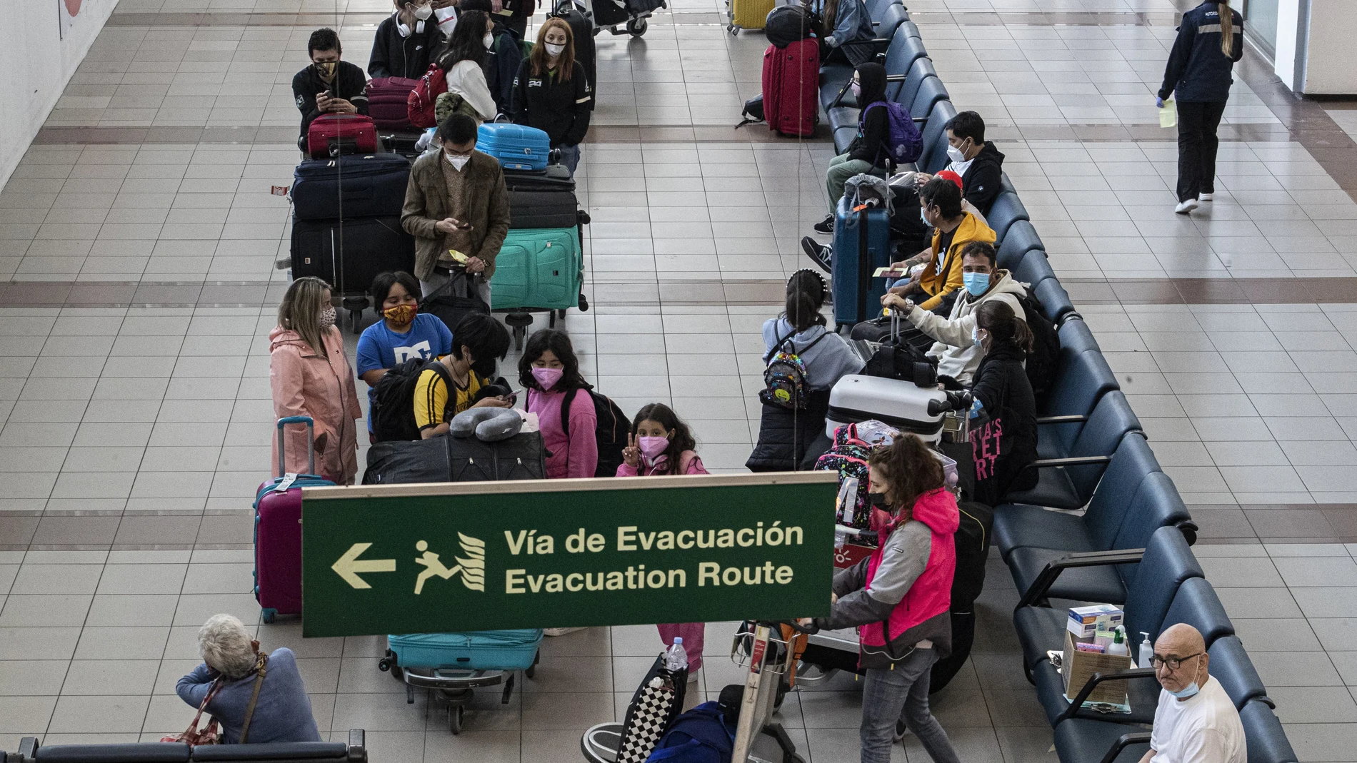 Arriving passengers wait to be transported to a hotel for a 5-day quarantine amid the coronavirus pandemic, at the Augusto Merino Benitez international airport in Santiago, Chile, Thursday, April 1, 2021. Chile has largely closed its borders to control surging COVID-19 cases despite a region-leading vaccine campaign, joining other South American countries in new moves to clamp down on movement. (AP Photo/Esteban Felix)