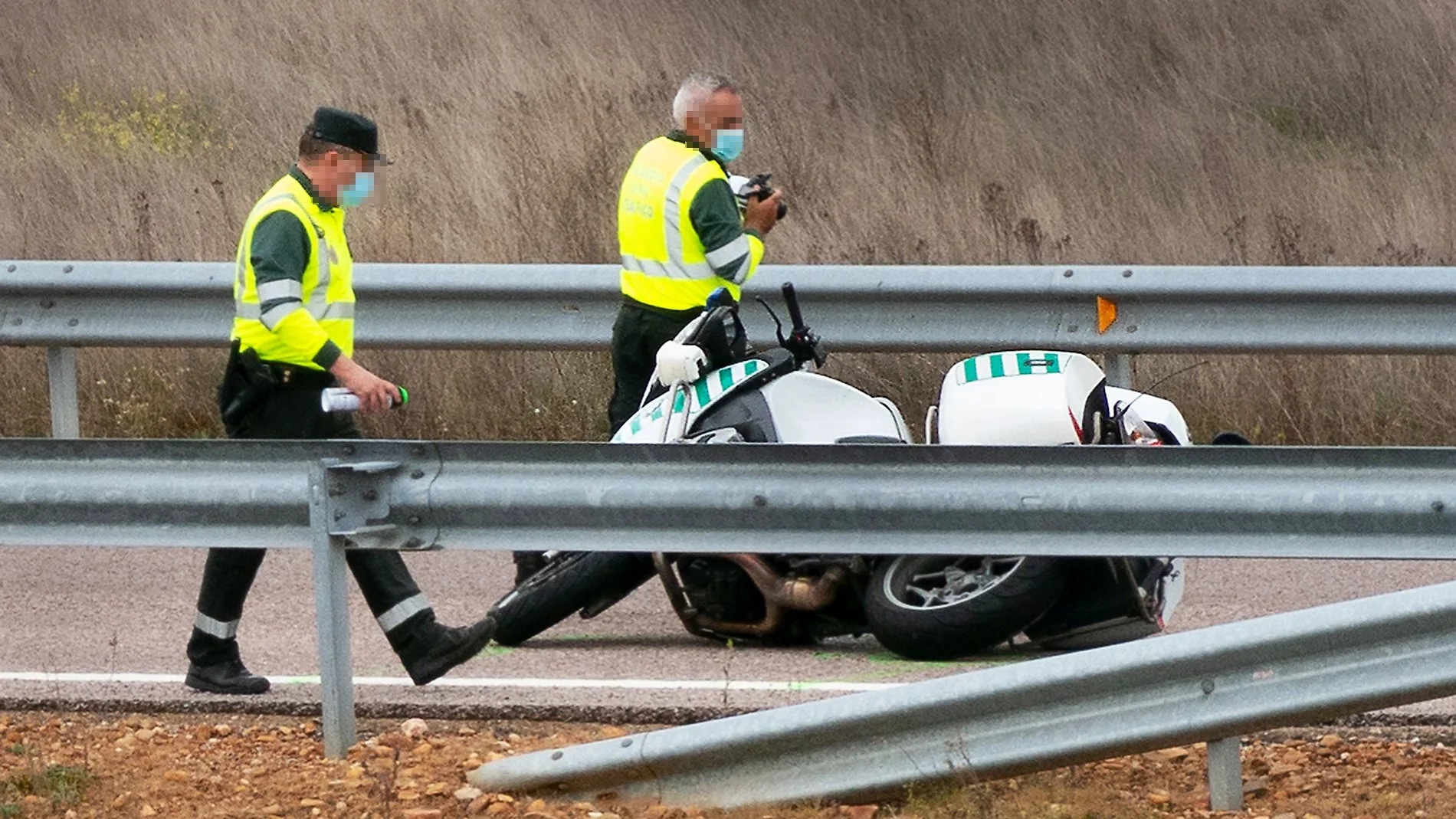 Dos guardias civiles junto a la moto en el lugar del accidente