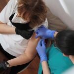 Una mujer recibe una vacuna en el Centro Cultural Miguel Delibes de Valladolid