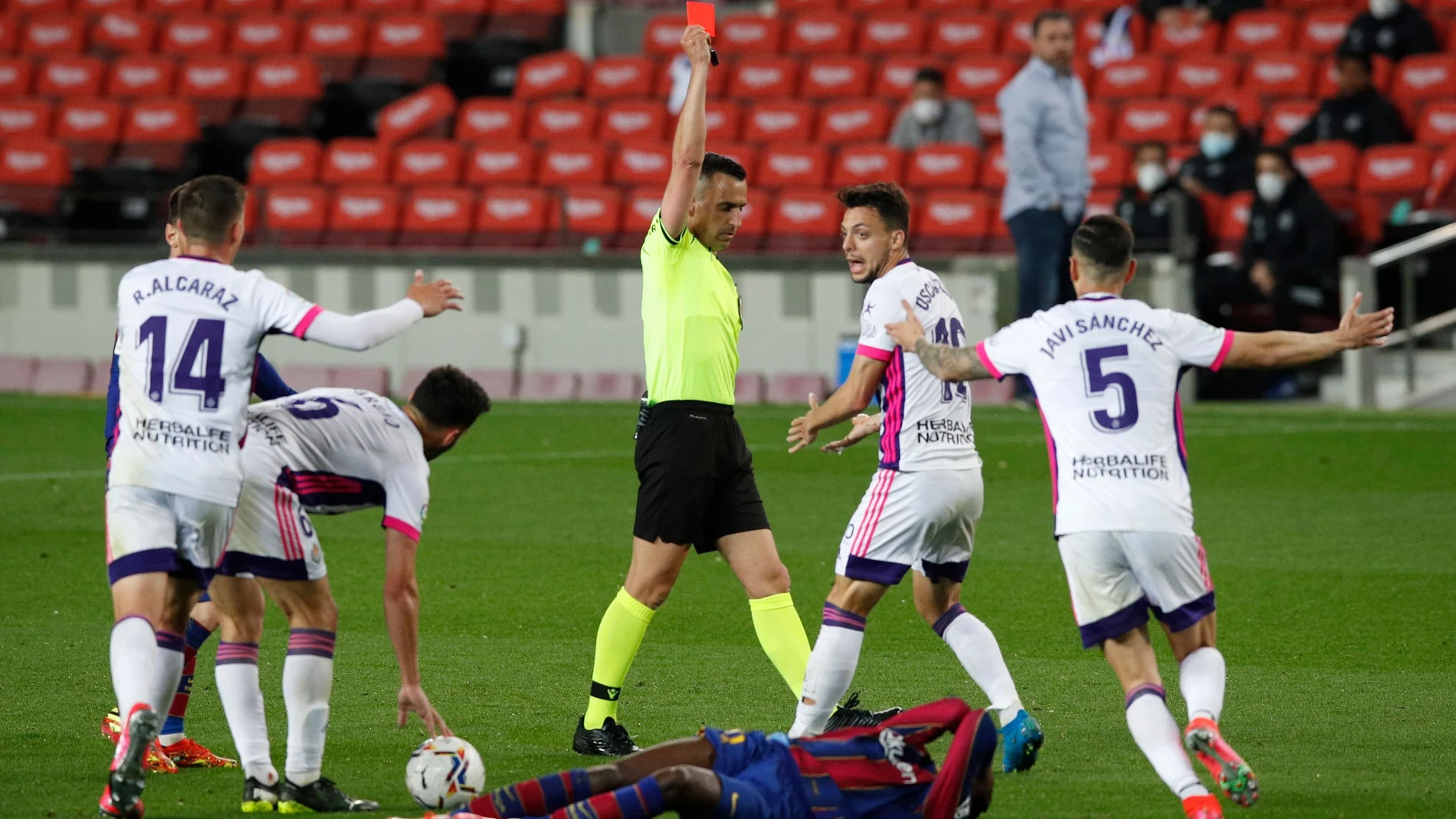 El árbitro Jaime Latre expulsa al jugador del Valladolid Óscar Plano.