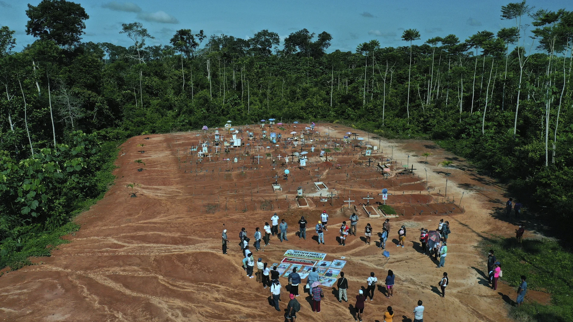 Relatives of people who died from COVID-19 gather next to a clandestine mass grave on the outskirts of Iquitos, Peru, Saturday, March 20, 2021. Local authorities approved the mass burials but never told the families, who believed their loved ones were interred in the nearby local cemetery — and only months later discovered the truth. (AP Photo/Rodrigo Abd)