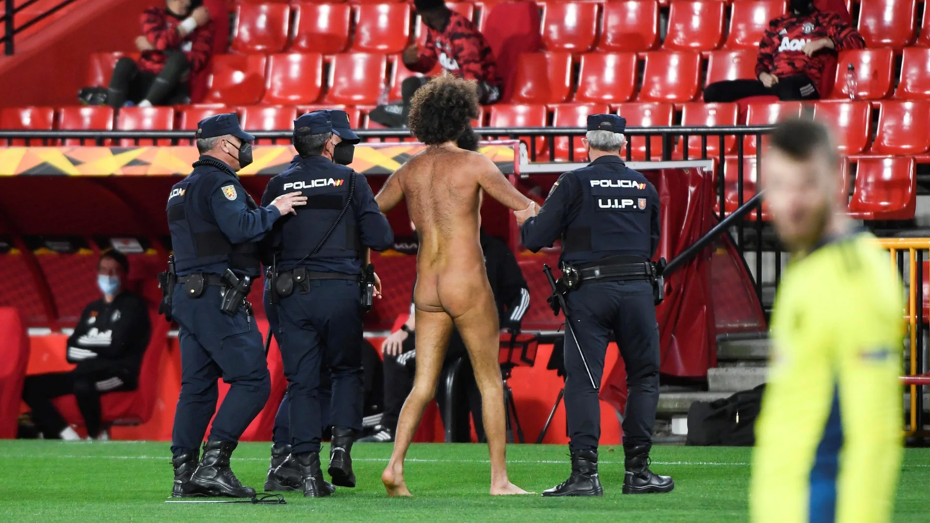 Miembros de la Policía Nacional detienen al hombre desnudo que saltó al terreno de juego del estadio Los Cármenes de Granada