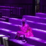 A woman waits for the start of a fashion show during the Mercedes-Benz Fashion Week in Madrid, Spain, (AP Photo/Paul White)