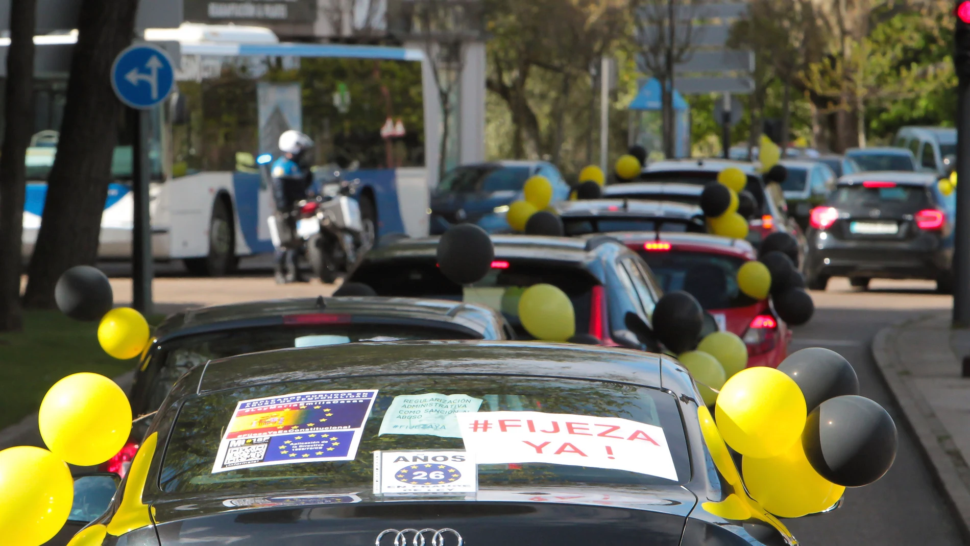 Varias personas participan con sus vehículos en una caravana contra el abuso de la temporalidad en el empleo público