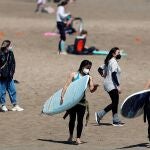 Un grupo de jóvenes disfruta de la playa de la Malvarrosa (Valencia) llevando mascarillas