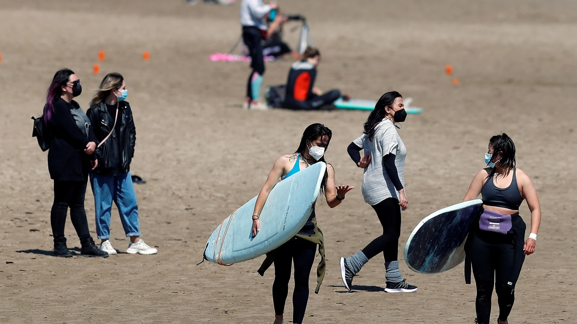 Un grupo de jóvenes disfruta de la playa de la Malvarrosa (Valencia) llevando mascarillas