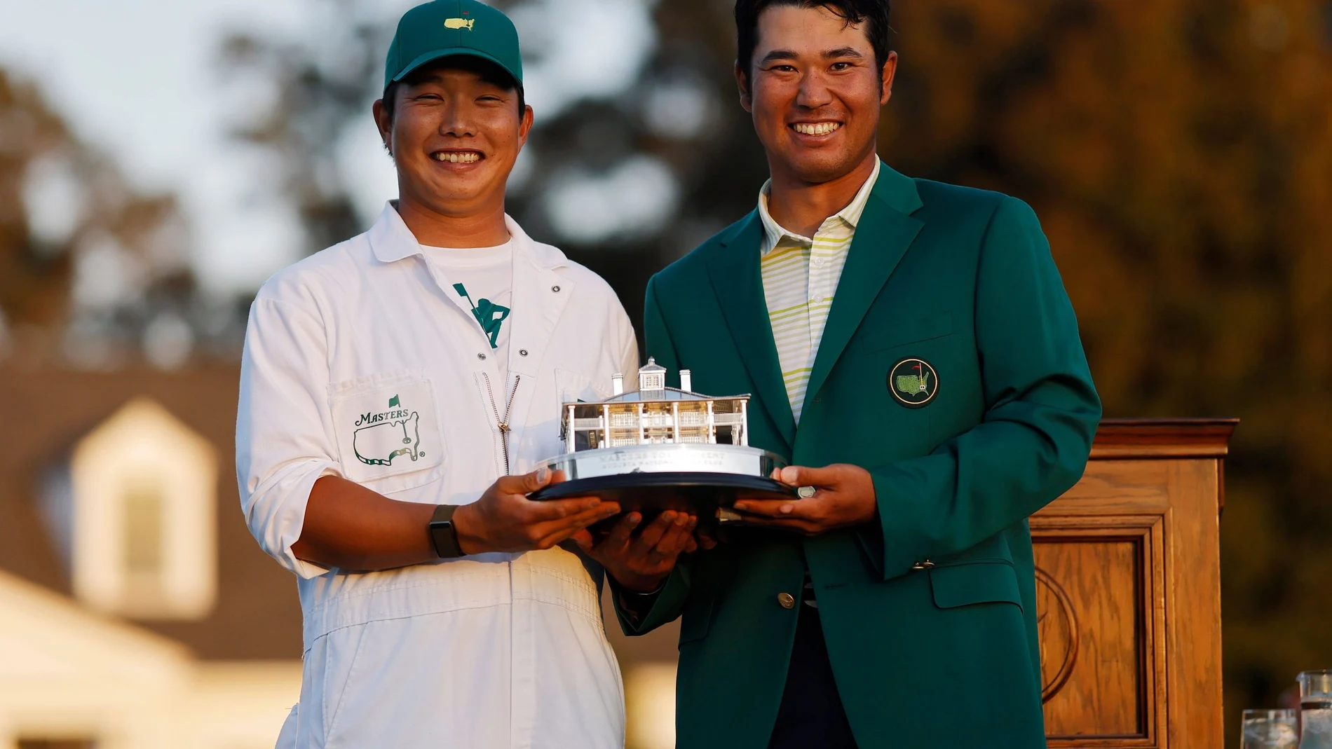 Hideki Matsuyama y su 'caddie' posan con el trofeo de ganadores del Masters de Augusta.