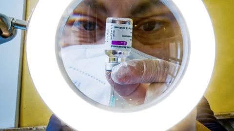 Un sanitario prepara las dosis de la vacuna contra la COVID-19, AstraZeneca,en un centro de vacunaciones en Nápoles