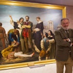 El comisario del Comité Científico de los Actos del Quinto Centenario del Movimiento Comunero, Salvador Rus, posa junto al cuadro "Los comuneros Padilla, Bravo y Maldonado en el patíbulo"