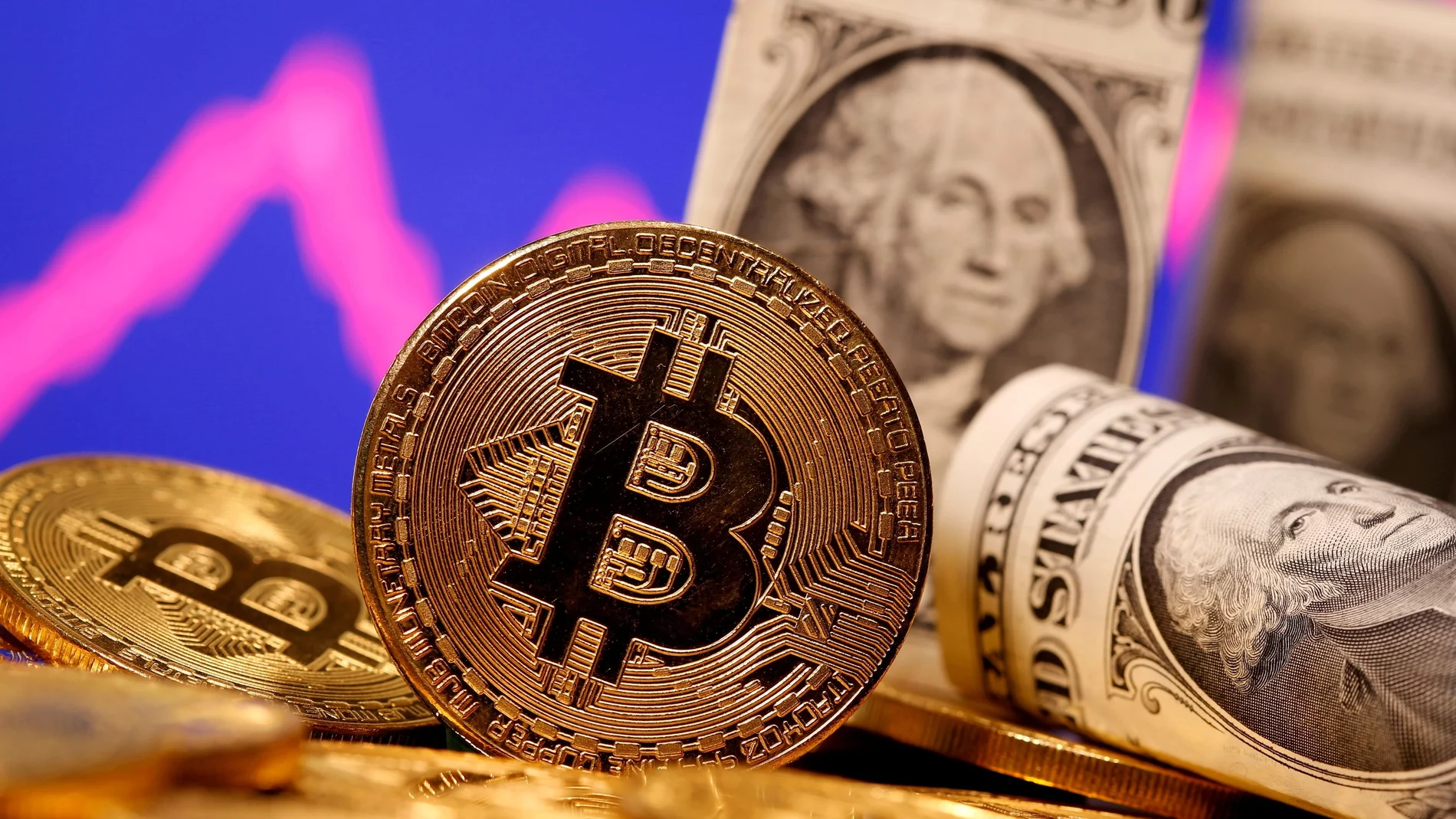 Representación de una criptomoneda o 'bitcoin' junto con dólares de EEUU