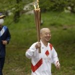 Un relevista porta la antorcha olímpica de los Juegos de Tokio en Suita, Osaka.