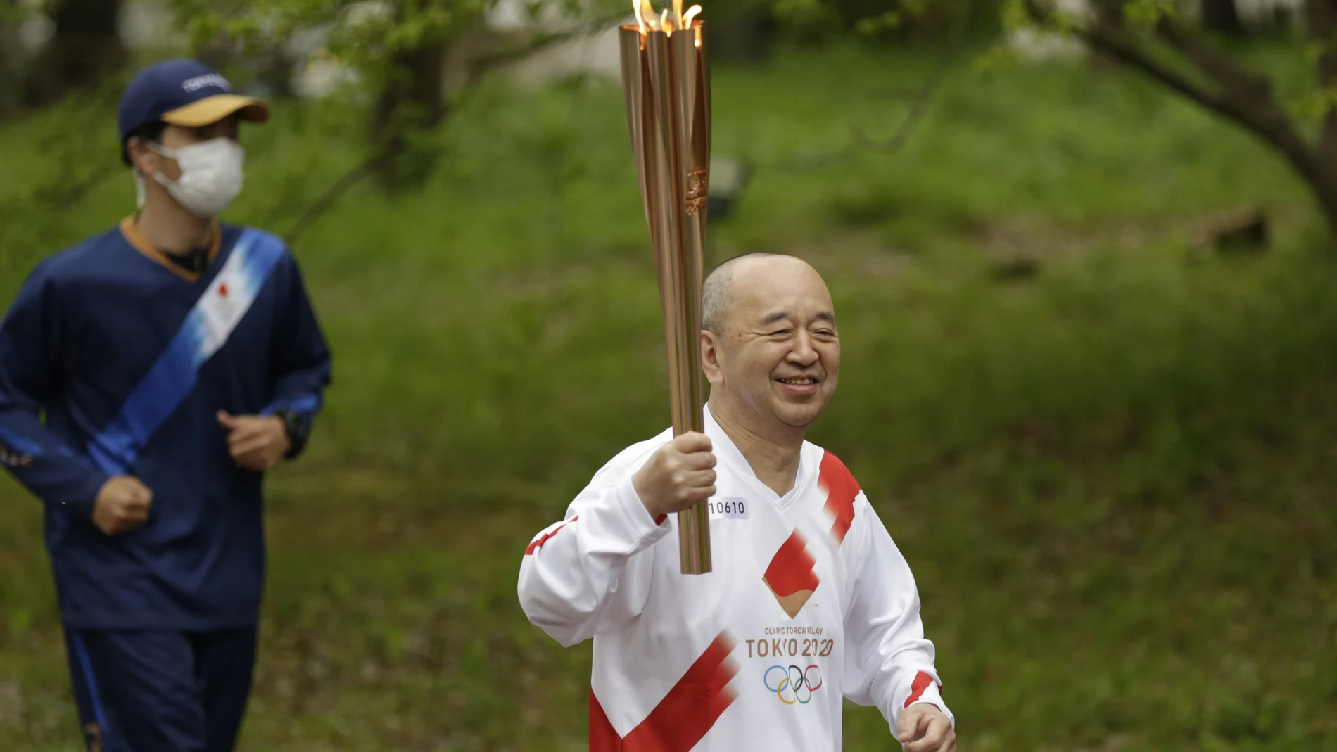 Un relevista porta la antorcha olímpica de los Juegos de Tokio en Suita, Osaka.