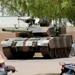 La gente pasa frente a un tanque del ejército de Chad cerca del palacio presidencial en N&#39;djamena