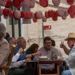 Un grupo de personas almuerzan en un bar decorado con los farolillos tradicionales