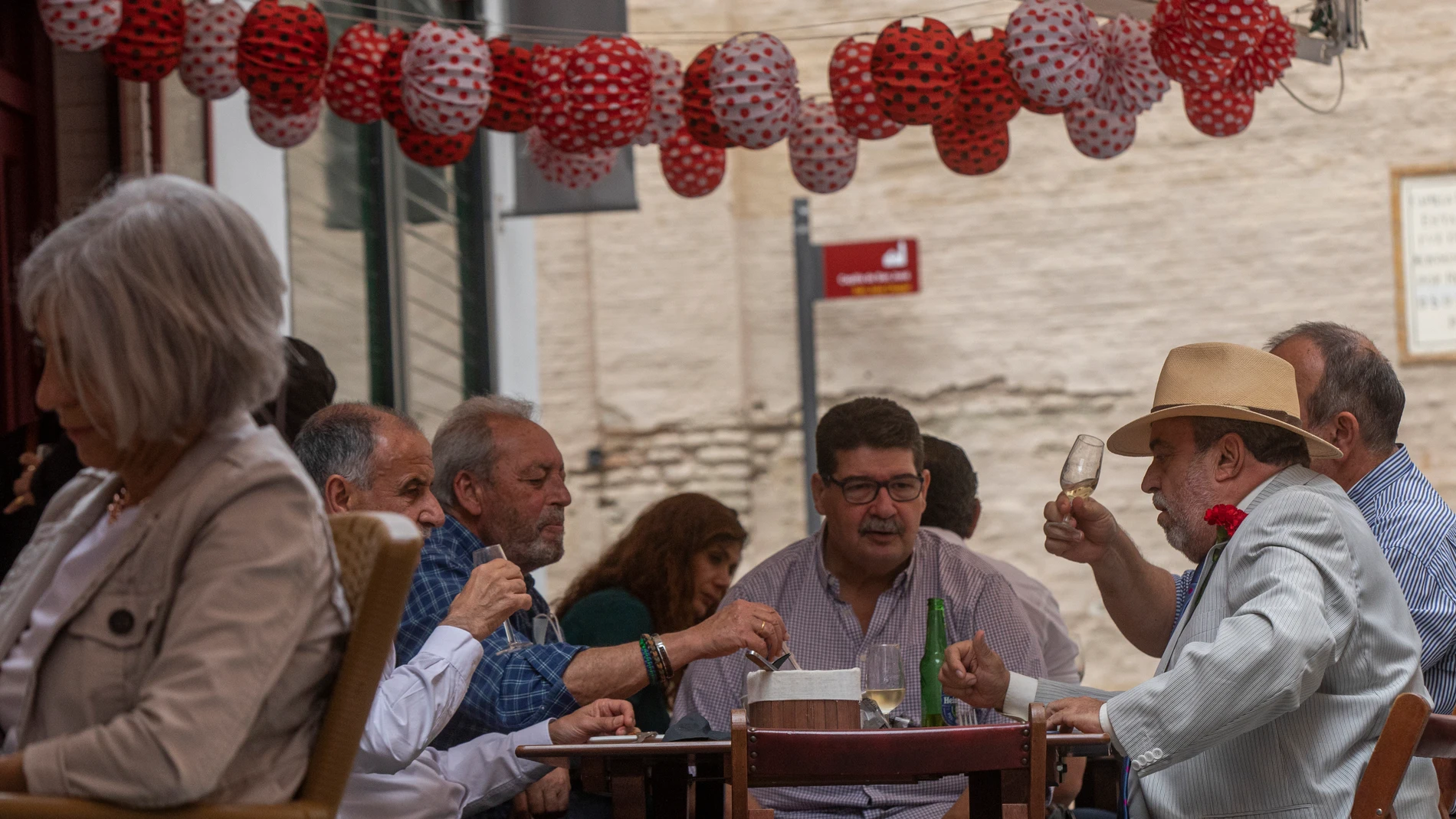 Un grupo de personas almuerzan en un bar decorado con los farolillos tradicionales