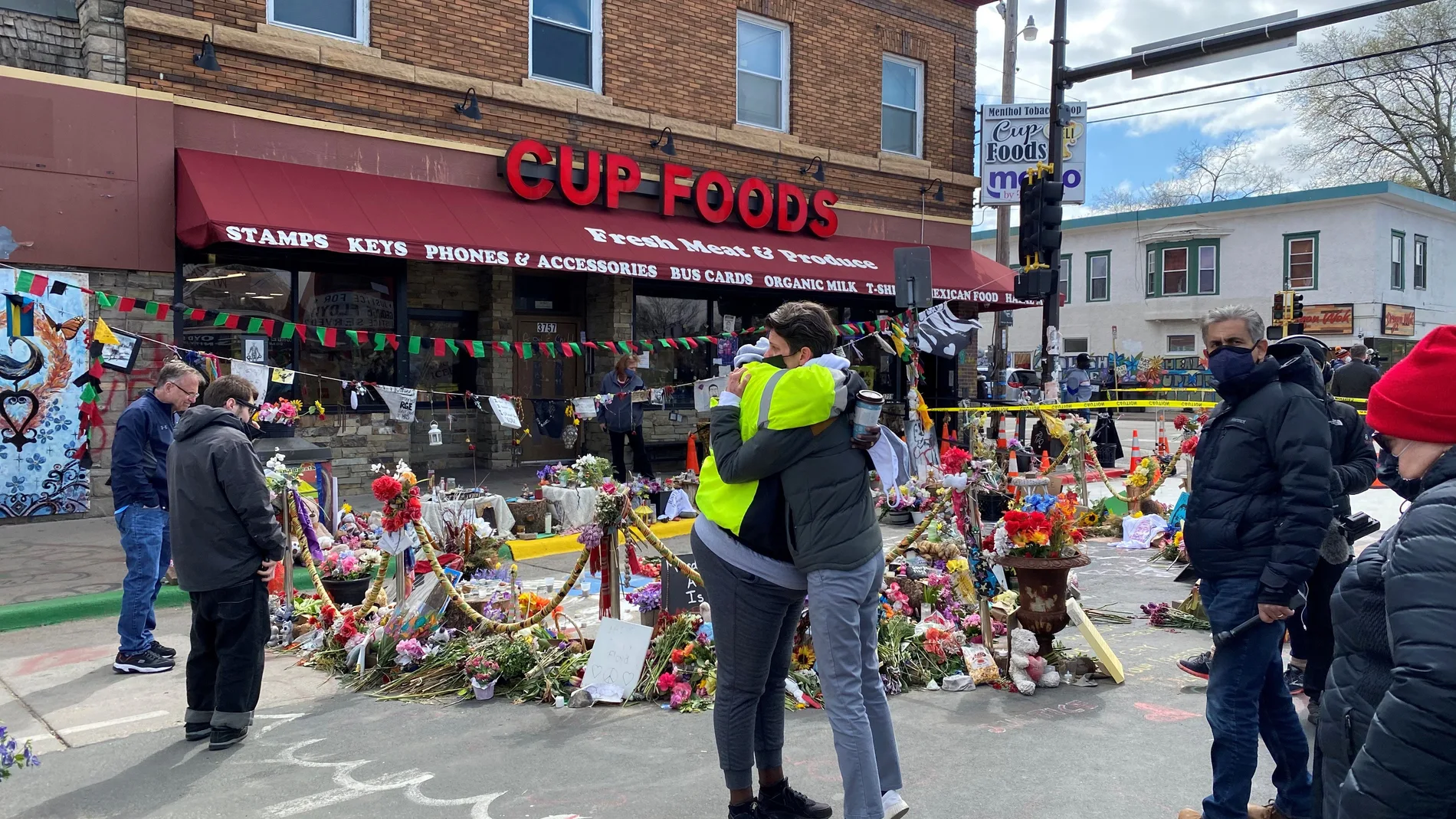 Dos personas se abrazan frente a la esquina en la que murió asfixiado George Floyd, durante una concentración en su honor en Mineápolis