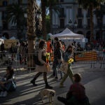 Varias personas caminan en la Plaza Real de Barcelona en el día de Sant Jordi