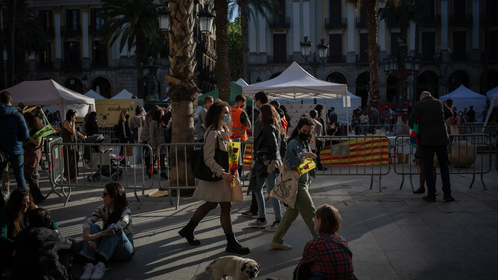 Varias personas caminan en la Plaza Real de Barcelona en el día de Sant Jordi