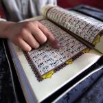 Un niño paquistaní lee versos del Corán