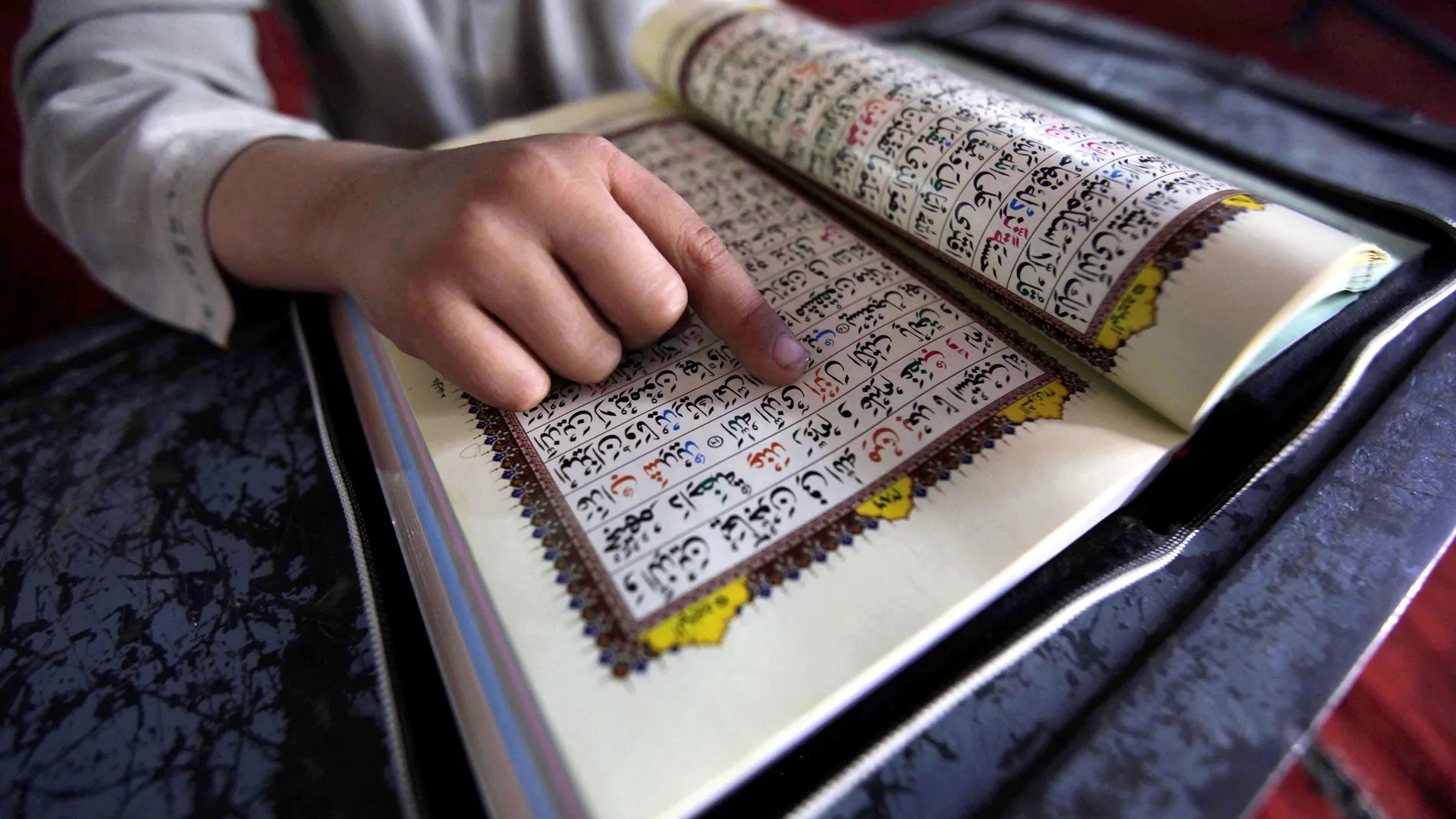Un niño paquistaní lee versos del Corán