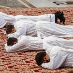 Los sacerdotes miran hacia el suelo durante la ceremonia de ordenación en la Basílica de San Pedro de ayer