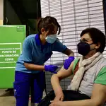 Una enfermera pone la vacuna de Janssen a una mujer en el punto de vacunación masiva en el Palacio de los Juegos del Mediterráneo de Almería
