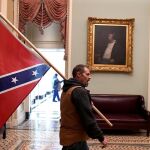 Un asaltante al Capitolio con la bandera de combate confederada