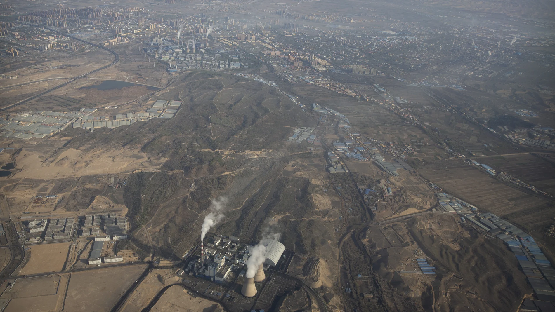 Smoke and steam rise from towers at the coal-fired Urumqi Thermal Power Plant in Urumqi in western China's Xinjiang Uyghur Autonomous Region, Wednesday, April 21, 2021. China, the world's biggest coal user, said Tuesday the fossil fuel will play a less dominant role in its energy mix and that, despite plans to build new coal-fired power plants, the country won't use it on a wide scale. (AP Photo/Mark Schiefelbein)