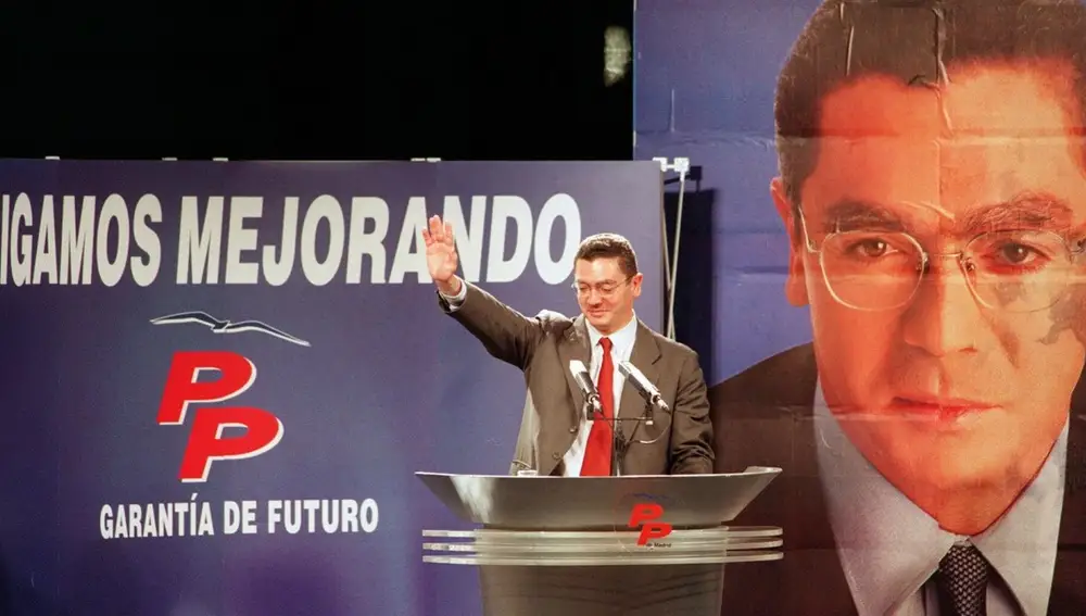 Gallardón durante la campaña de 1999, con el cartel electoral del PP de fondo