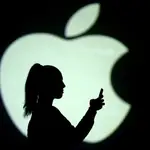 FILE PHOTO: Silhouette of a mobile user seen next to a screen projection of the Apple logo in this picture illustration taken March 28, 2018. REUTERS/Dado Ruvic/Illustration//File Photo