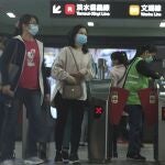 Un grupo de viajeros con mascarillas abandona la estación de Taipei