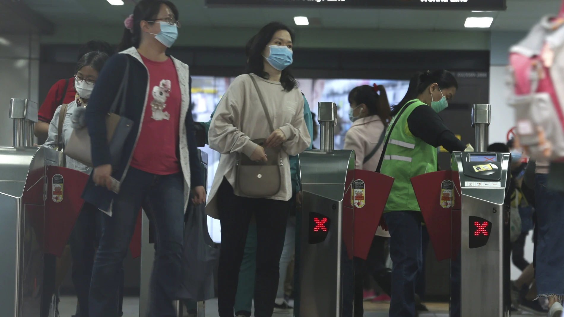 Un grupo de viajeros con mascarillas abandona la estación de Taipei