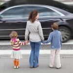 Madre de la mano de sus hijos a punto de cruzar por un paso de peatones