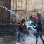Un manifestante se enfrenta a miembros de la policía durante una jornada de protestas contra la reforma tributaria en Bogotá