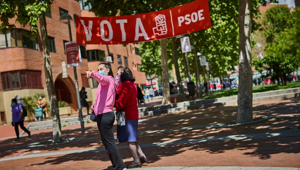 Dos mujeres bajo un cartel del PSOE en la emblemática plaza de Vallecas