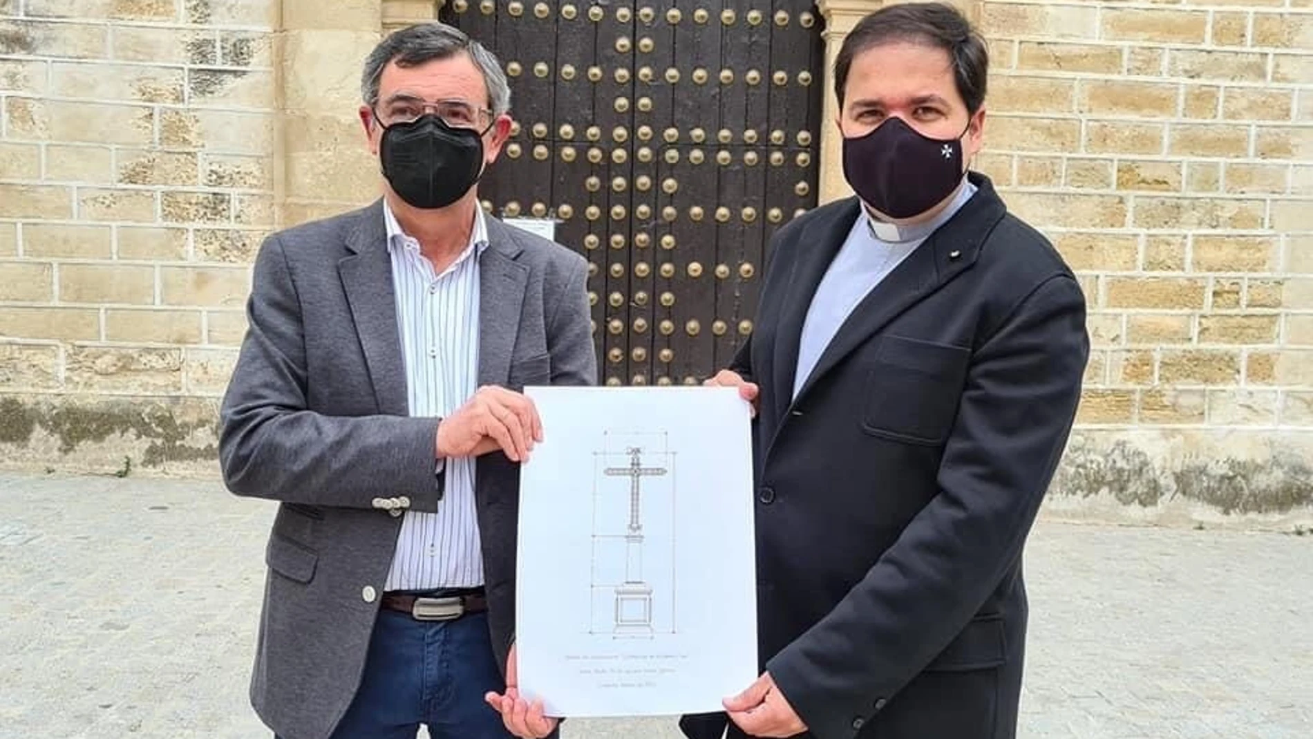 El presidente de la Agrupación de Cofradías de Aguilar, José Cabezas, presenta el boceto de la nueva cruz junto al párroco de Aguilar Pablo Lora