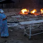 Una mujer llora durante la cremación de su esposo en un crematorio en Nueva Delhi