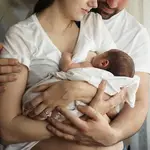 Una mujer da de mamar a su bebé