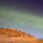 Un patrón de onda constante teñido de verde se puede ver en el evento de la aurora boreal similar a una duna.