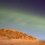 Un patrón de onda constante teñido de verde se puede ver en el evento de la aurora boreal similar a una duna.