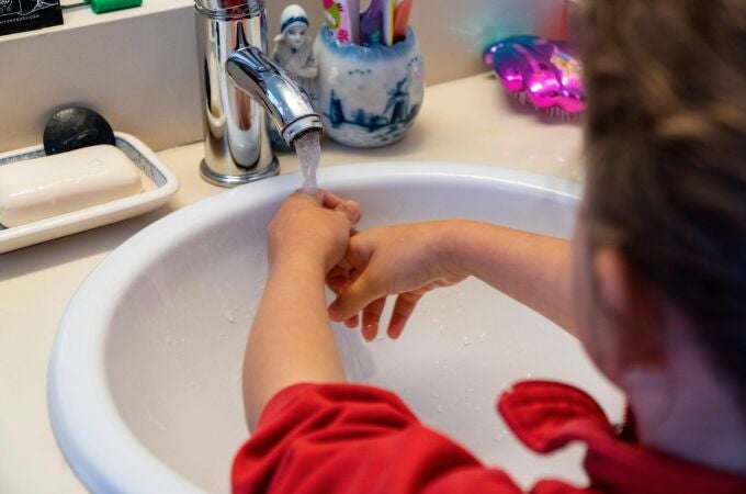Una niña se lava las manos en casa