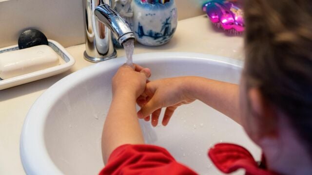Una niña se lava las manos en casa