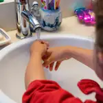Una niña se lava las manos en casa