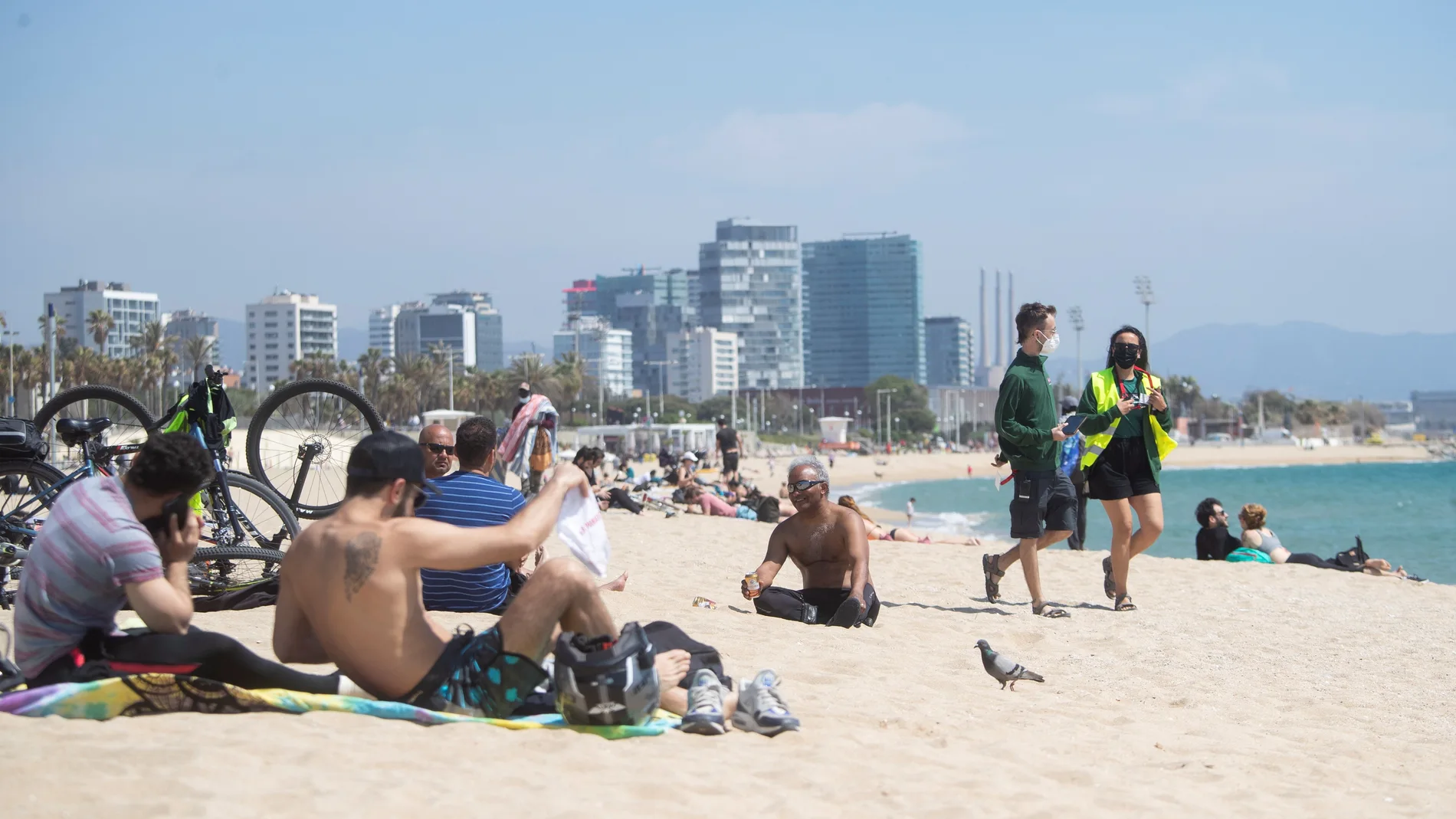 Dos operarios del Ayuntamiento de Barcelona controlan el aforo de las siempre concurridas playas de la capital catalana, un dispositivo de control que se activa esta semana