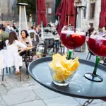 Imagen de un camarero llevando dos tintos de verano a una mesa de una terraza en Madrid.