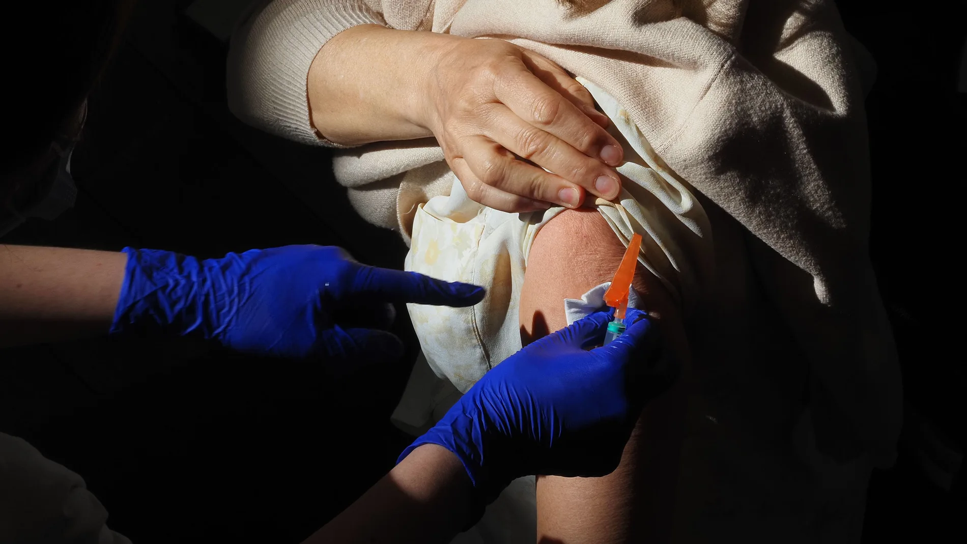 Un trabajador sanitario suministra la vacuna contra el Covid-19 a una persona, en el Centro Cultural Miguel Delibes